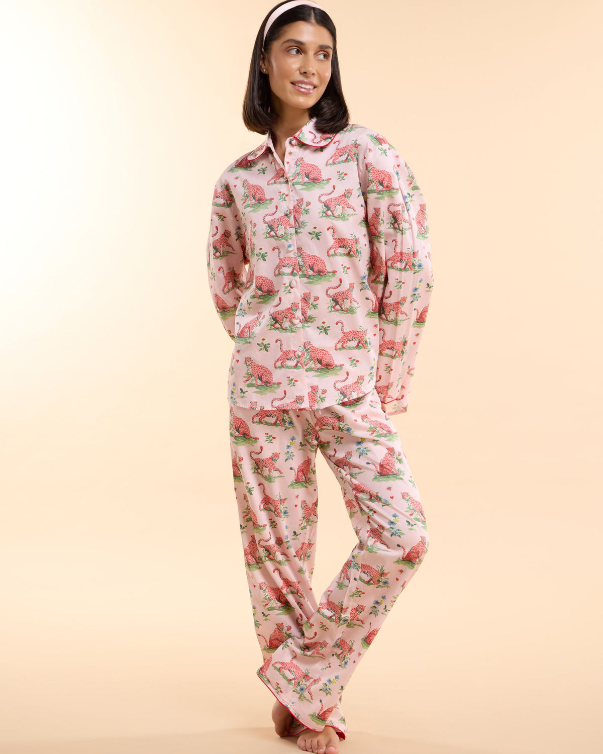 Model wearing the Layla Pink Long PJ Set, a blush pink leopard print cotton pyjama set with long-sleeve shirt and trousers, by Love Letters x